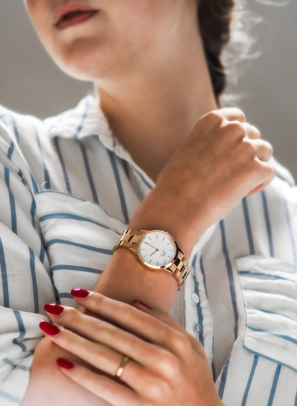 Las manos cruzadas de una mujer y en una de las muñecas trae puesto un reloj de manecillas.