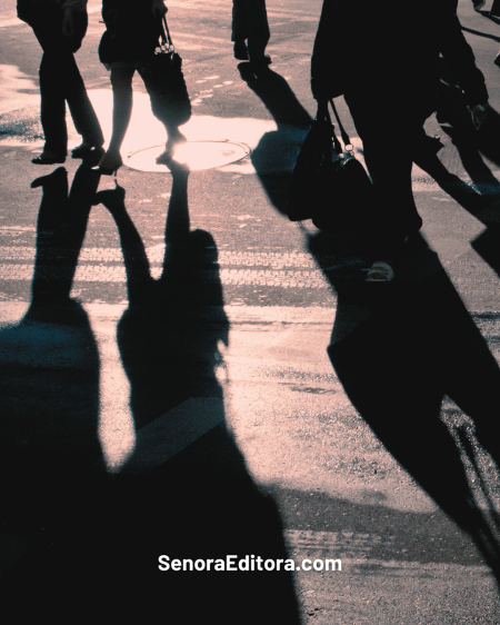 Se ve la figura de personas caminando en una calle, a contra luz, se ve la sombra proyectándose en el pavimento, como con un sentimiento de nostalgia.