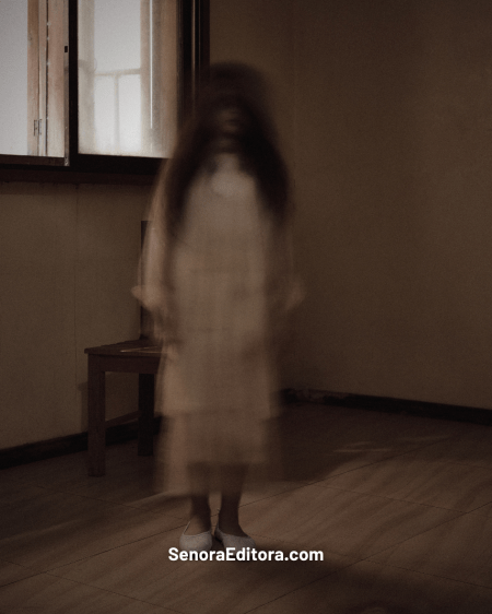 La imagen de una niña fantasma de pie en el centro de una habitación. Se ve borrosa.